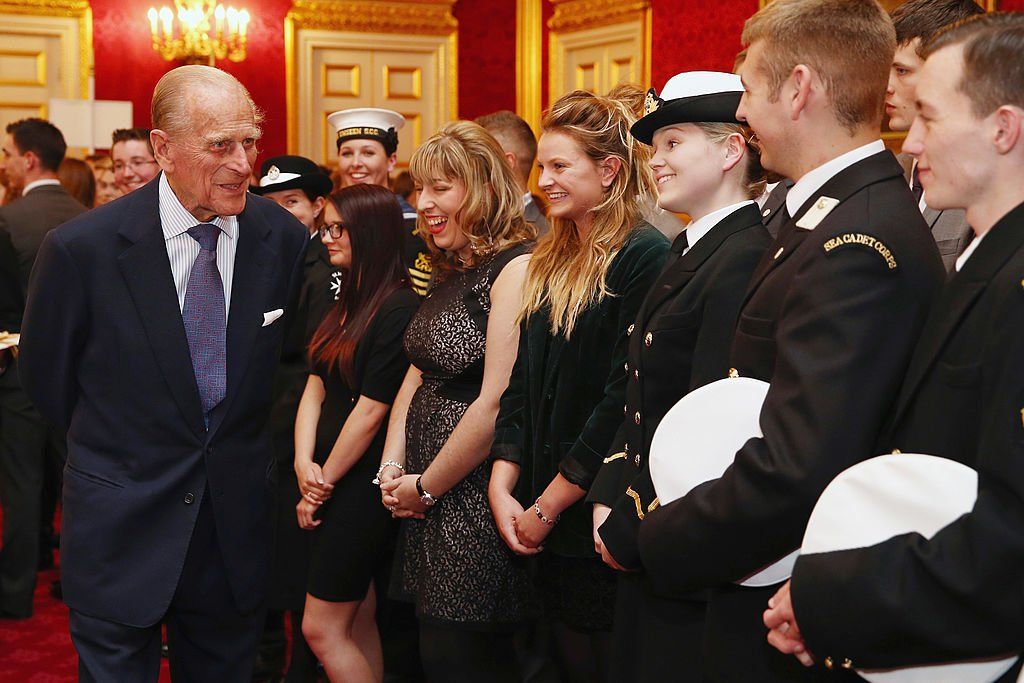 Duke of Edinburgh speaks with a group of young people during a reception at St. Jamess Palace on October 10, 2013 | Photo: Getty Images