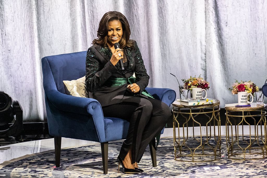 Michelle Obama kriví krivky v modrej obleku a sieťových pätách, zatiaľ čo na Oprah 2020 Vision Tour
