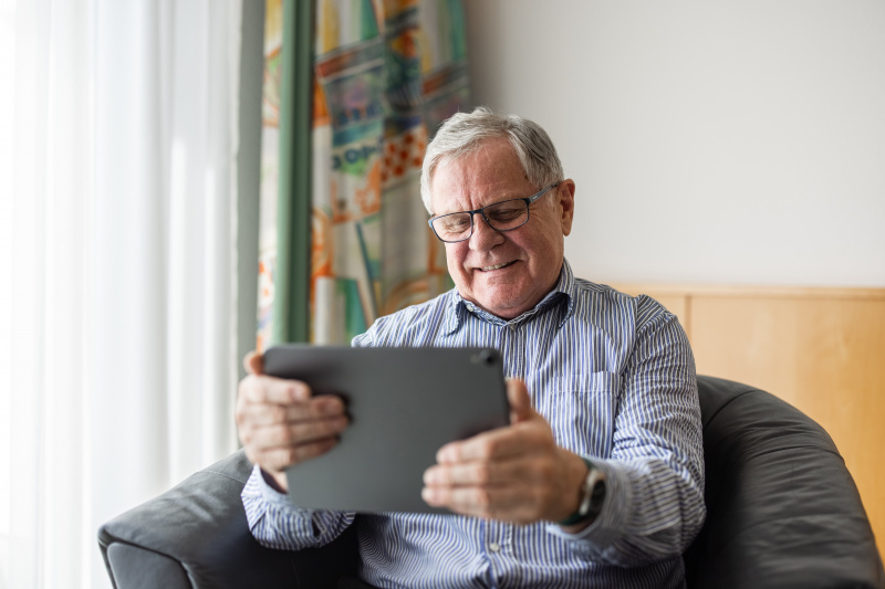   Un vecchio seduto a casa che usa una tavoletta digitale per le videochiamate | Fonte: Getty Images